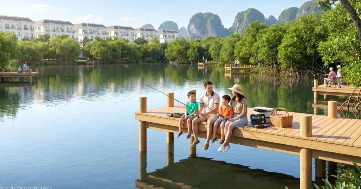 Gia đình câu cá trên cầu gỗ ven hồ, phía sau là dãy nhà thấp tầng tại Vinhomes New City